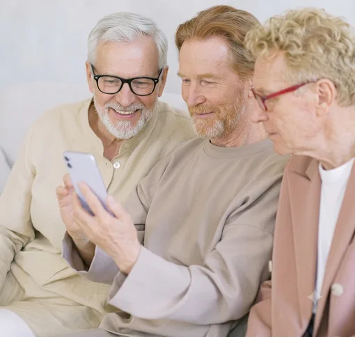 Three people sharing a phone screen and smiling together